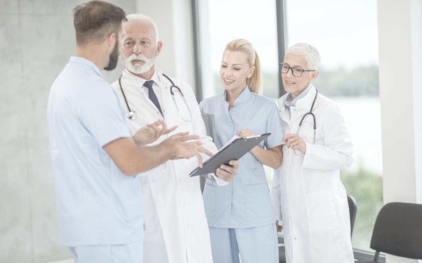 Nhóm bác sĩ cùng xem hồ sơ bên cửa sổ phòng hội chẩn