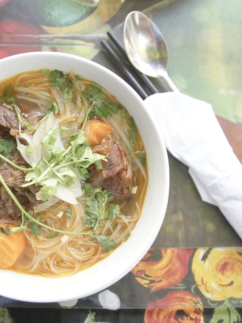 Tô phở bò nóng với hành và rau thơm